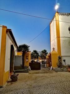 un grupo de edificios con palmeras en una calle en Herdade da Diabroria - Agroturismo, en Beringel