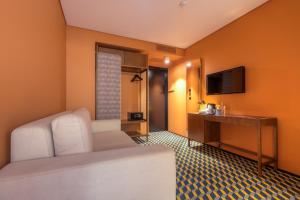 a hotel room with a bed and a television at The Convo Porto Hotel & Suites in Porto