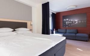 a bedroom with a large bed and a couch at Torget Aparthotel in Pori