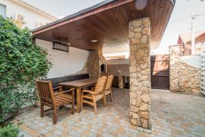 an outdoor patio with a wooden table and chairs at Villa Bugaz in Zatoka