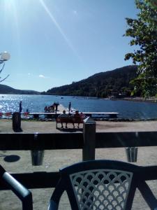 two people sitting on a bench next to a lake at Le Trèfle d'Or in Gérardmer +7 photos