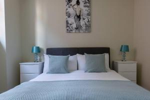 una camera da letto con un letto con due lampade e una foto a parete di Apartment 4, Isabella House, Aparthotel, By RentMyHouse a Hereford