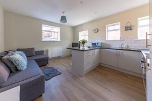 a large living room with a couch and a kitchen at Hereford City Centre - Apartment 4, Isabella House - Modern Apartment In The Heart of The City - Sleeps 4 Guests - Hosted by RENTMYHOUSE in Hereford