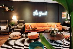 - un salon avec un canapé et des chaises orange dans l'établissement The Yard Hostel, à Helsinki