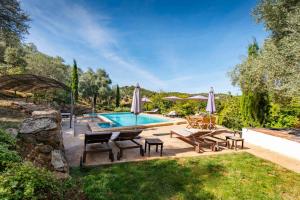 a backyard with a pool and chairs and a table at Los Pozos de la Nieve in Constantina