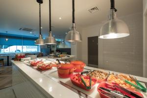 a kitchen with a counter with bowls of food on it at Holiday Inn Swindon, an IHG Hotel in Swindon