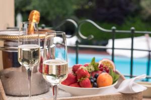 - une table avec deux verres de vin et un bol de fruits dans l'établissement Locanda I Girasoli, à Misano Adriatico