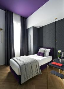 ミラノにあるConti Guest Houseの紫色の天井のベッドルーム1室(大型ベッド1台付)