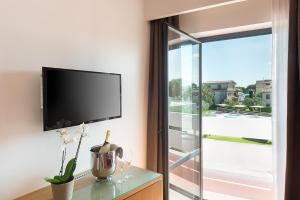 a flat screen tv on a wall next to a window at Rada Siri in Montepaone