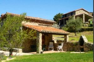 a view of a stone house with a patio at Mi Valle Rural in Casas del Castañar
