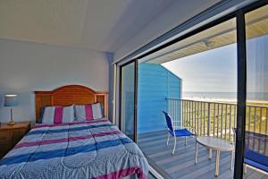 a bedroom with a bed and a balcony at On the Beach, Walk to Village, Watch the Sunsets from Balcony in Siesta Key