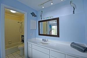 a bathroom with a sink and a mirror at On the Beach, Walk to Village, Watch the Sunsets from Balcony in Siesta Key +31 photos