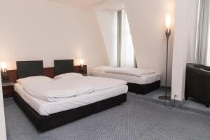 a hotel room with two beds and a television at sweet dream hostel & pension - Self Check-In in Güstrow