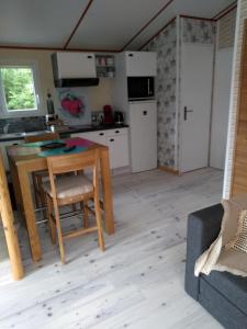 cocina y sala de estar con mesa y sofá en le haut village Chambre d'hôtes Mobi-Loft cosy sauna ,douche ,chromothérapie, en Arrest