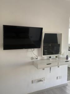TV de pantalla plana colgada en una pared blanca en Top floor apartment in Nicosia with view!, en Nicosia