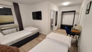 ein kleines Zimmer mit zwei Betten und einem Schreibtisch in der Unterkunft Moes Diner Hotel in Schloß Holte-Stukenbrock
