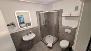 ein Badezimmer mit Dusche, Toilette und Waschbecken in der Unterkunft Moes Diner Hotel in Schloß Holte-Stukenbrock