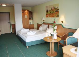 a hotel room with a bed and a table at Landhotel Napoleon in Wipperfürth +35 photos