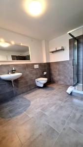 łazienka z 2 umywalkami, wanną i prysznicem w obiekcie Moes Diner Hotel w mieście Schloß Holte-Stukenbrock