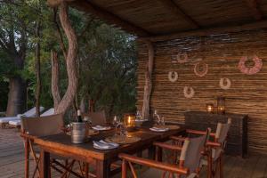 einen Holztisch und Stühle auf einer Terrasse in der Unterkunft Baobab Ridge in Klaserie Private Nature Reserve