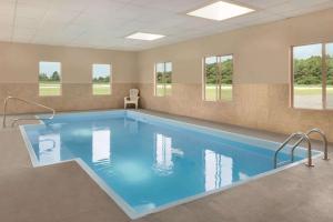 una gran piscina en una habitación con ventanas en Baymont by Wyndham Swanton en Swanton