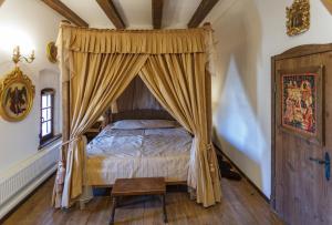 a bedroom with a canopy bed and a wooden floor at БУТИК-ОТЕЛЬ «VIA REGIA» in Radomyshlʼ