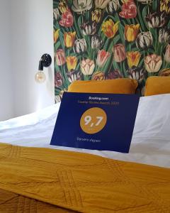 a bed with a blue sign on top of it at Ververs slapen in Den Bosch