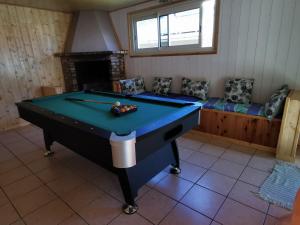 a room with a pool table and a couch at Au Pied des Sources in Cilaos