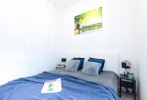 別爾斯科－比亞瓦的住宿－Lucky Place CENTRUM，白色卧室配有蓝色的床和蓝色枕头