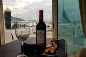uma garrafa de vinho e um copo sobre uma mesa em Yate de lujo en getxo Luxury yacht in Getxo em Getxo