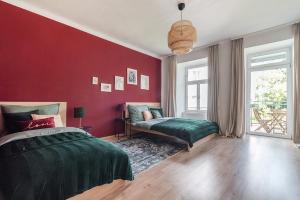 een slaapkamer met een bed en een rode muur bij Colorful Apartment Facing Green Courtyard in Wenen