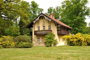 a large house with a balcony on top of a field at Kavalierhaus im Rhododendronpark Kromlau in Gablenz