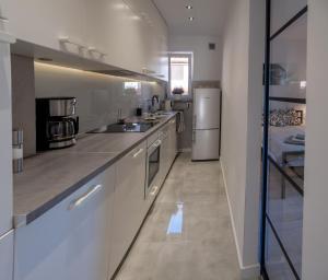 Una cocina grande con gabinetes blancos y un refrigerador. en Apartament Młociny, en Varsovia