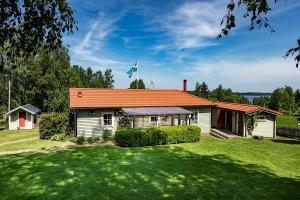 uma casa com um telhado laranja num jardim verde em Luxury Villa by lake welcome you em Hjo