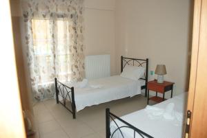 1 Schlafzimmer mit 2 Betten und einem Fenster in der Unterkunft Villa Maria in Ierissós