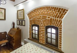 a brick fireplace in a bedroom with a bed at БУТИК-ОТЕЛЬ «VIA REGIA» in Radomyshlʼ