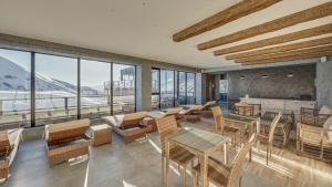 a room with tables and chairs and windows at Apartment #513 in Gudauri Loft Hotel in Gudauri