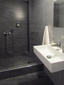a bathroom with a shower and a sink and a shower at Perdika Mare Guesthouse in Perdika