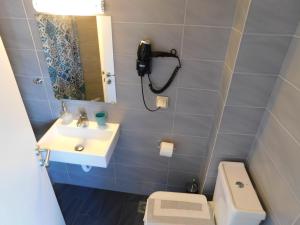 a bathroom with a sink and a toilet and a mirror at Perdika Mare Guesthouse in Perdika