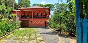 a red house with a driveway leading to it at Casa do Lago in Cunha