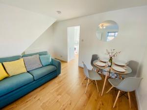 ein Wohnzimmer mit einem blauen Sofa und einem Tisch in der Unterkunft Wilnecote House in Tamworth