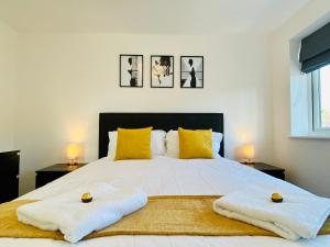 a bedroom with a large white bed with yellow pillows at Wilnecote House in Tamworth