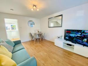 a living room with a couch and a flat screen tv at Wilnecote House in Tamworth