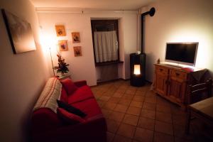 uma sala de estar com um sofá vermelho e uma televisão de ecrã plano em Tà fratte em Padola