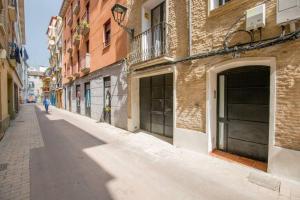 una persona caminando por una calle en un callejón en CA1 - Apartamento céntrico de 1 dormitorio con opción de garaje, en Zaragoza