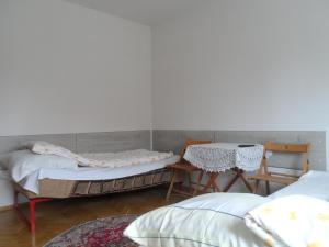 ポズナンにあるKwatery Pokoje Miraのベッド2台、テーブル、椅子が備わる客室です。