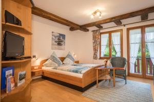 1 dormitorio con 1 cama, TV y mesa en Ferienwohnung Risthof 4, en Owingen