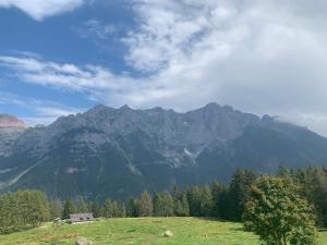 a view of a mountain range with a house in a field at residence bungalow-Marmore in Folgarida