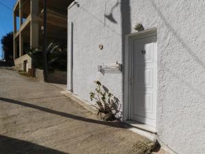 a white door on the side of a building at Perdika Mare Guesthouse in Perdika