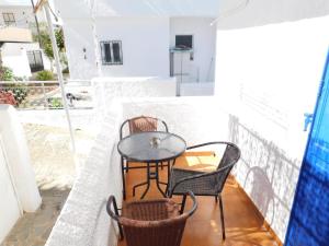 a small table and chairs on a balcony at Perdika Mare Guesthouse in Perdika